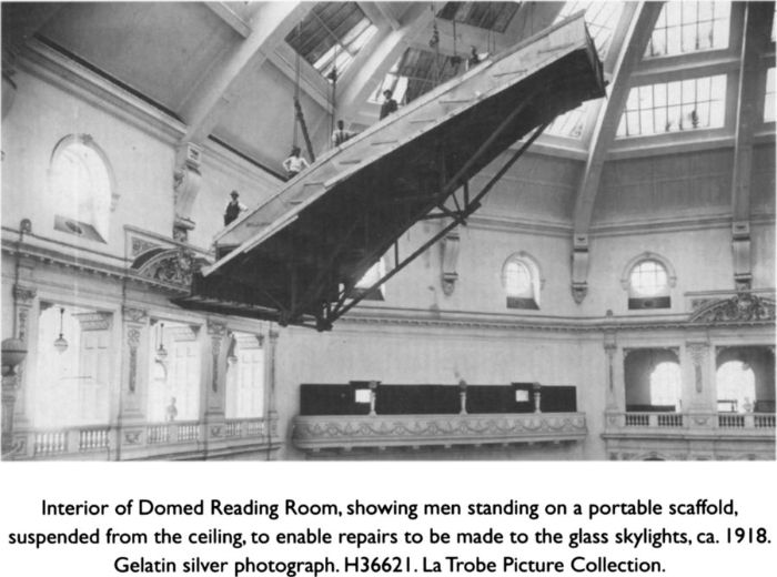 Top: Interior of Domed Reading Room, showing men standing on a portable scaffold, suspended from the ceiling, to enable repairs to be made to the glass skylights, ca. 1918. Gelatin silver photograph. H36621. La Trobe Picture Collection.