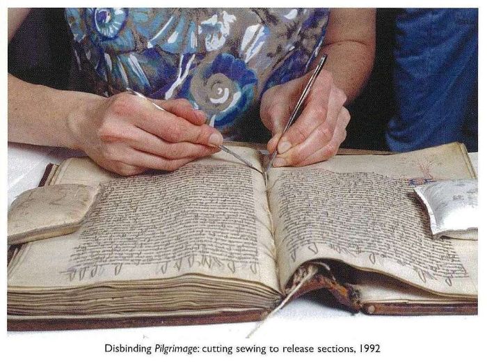 Disbinding Pilgrimage: cutting sewing to release sections, 1992 [book open, showing sewn binding being cut]